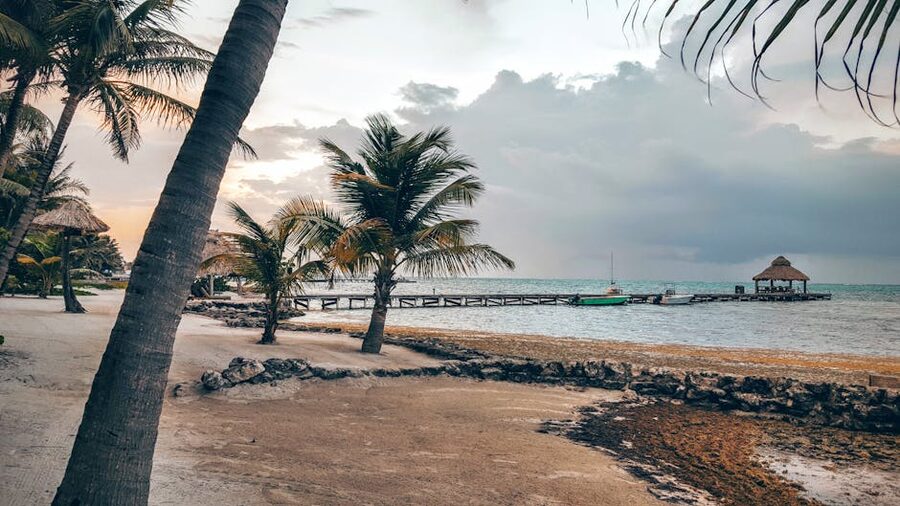 Wooden pier extending into calm water at sunset in San Pedro on Ambergris Caye, Belize