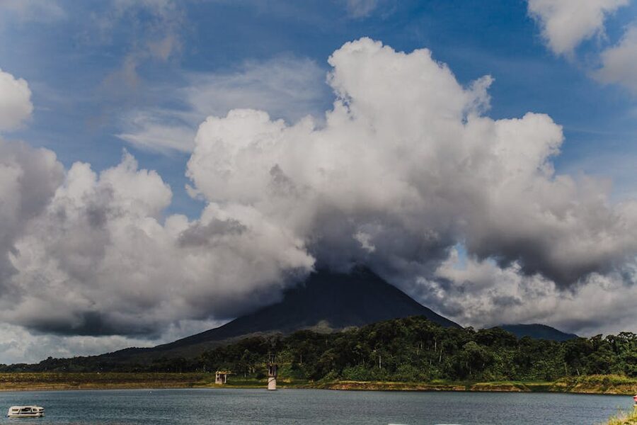 Arenal Volcano cone with cloud cap and lake in Costa Rica