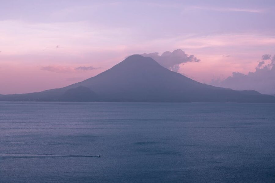 Lake Atitlan sunset with volcano silhouette and orange sky