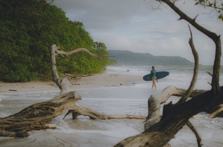 Surfer walking on Tamarindo beach Costa Rica