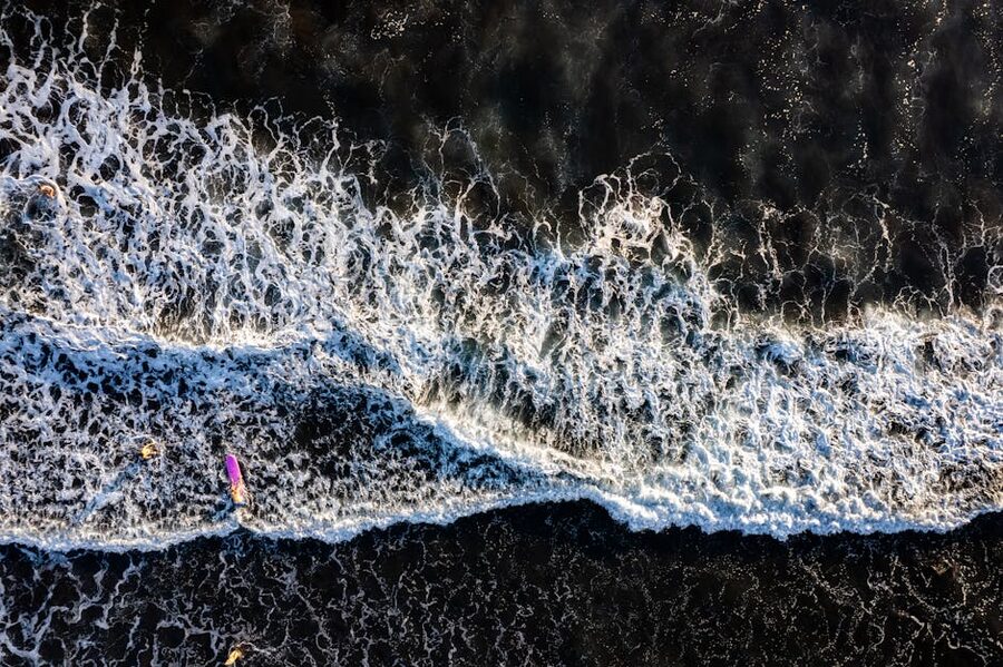 Aerial view of surfers riding waves at El Zonte beach, El Salvador