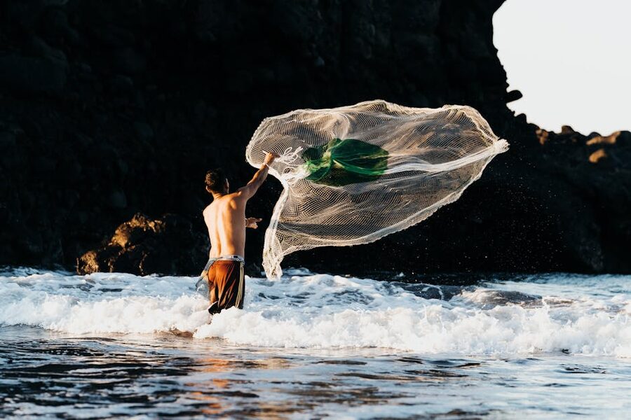 Fisherman casting a net at El Tunco beach, El Salvador