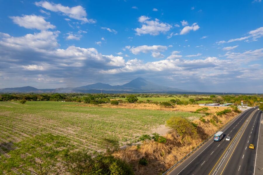 Highway through fields with mountains in El Salvador