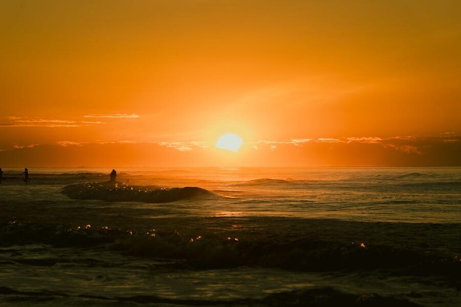 Surfers at Pacific sunset in El Salvador