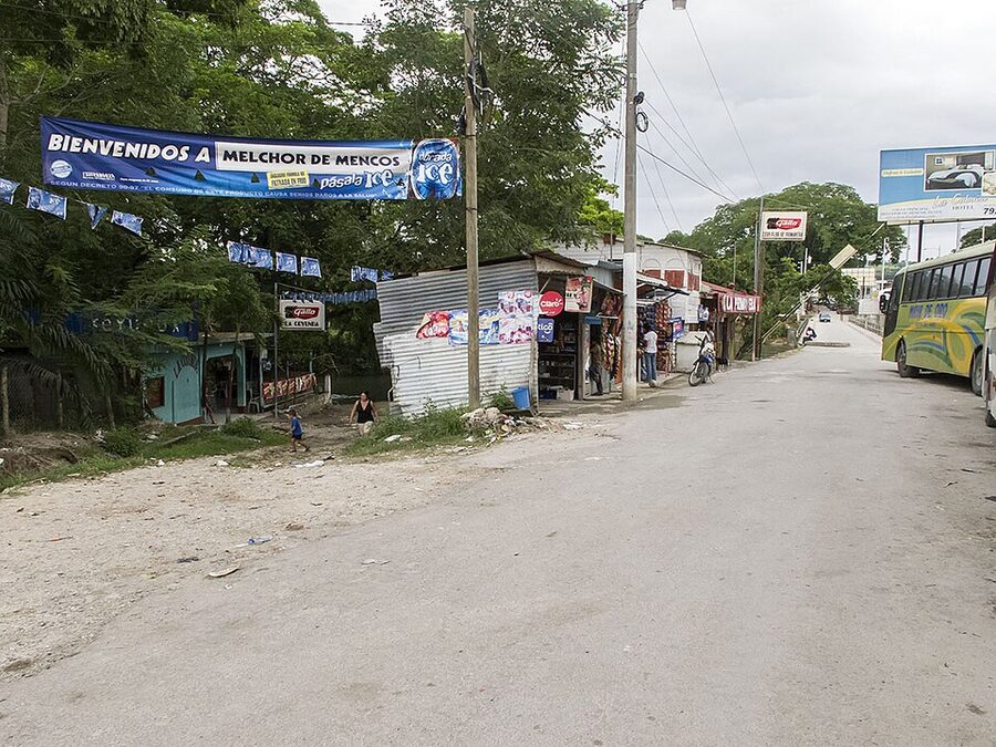 Welcome banner reading Bienvenidos a Melchor de Mencos at the small frontier town entrance