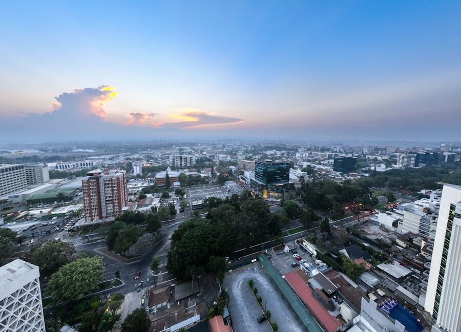 Aerial view of Guatemala City at sunset with mountains in the background