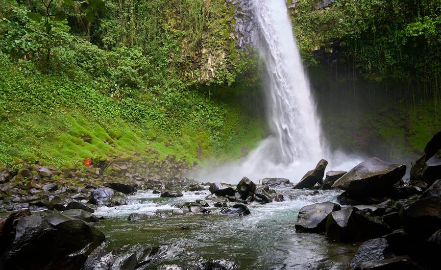 La Fortuna Waterfall with rocks and surrounding greenery
