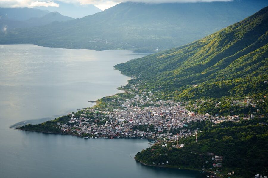Aerial view of a Lake Atitlan village hugging the shoreline with surrounding mountains
