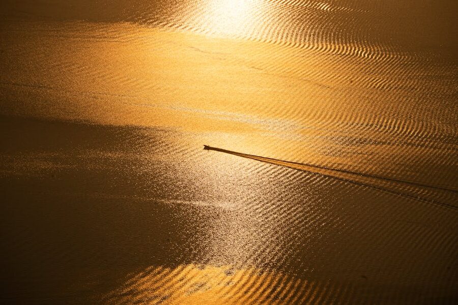 Golden sunset boat ride on Lake Atitlan with mountains in the distance