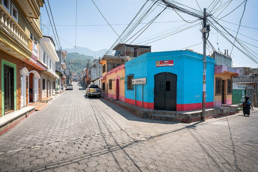 Santiago Atitlan cobblestone street with painted blue corner building and traditional houses