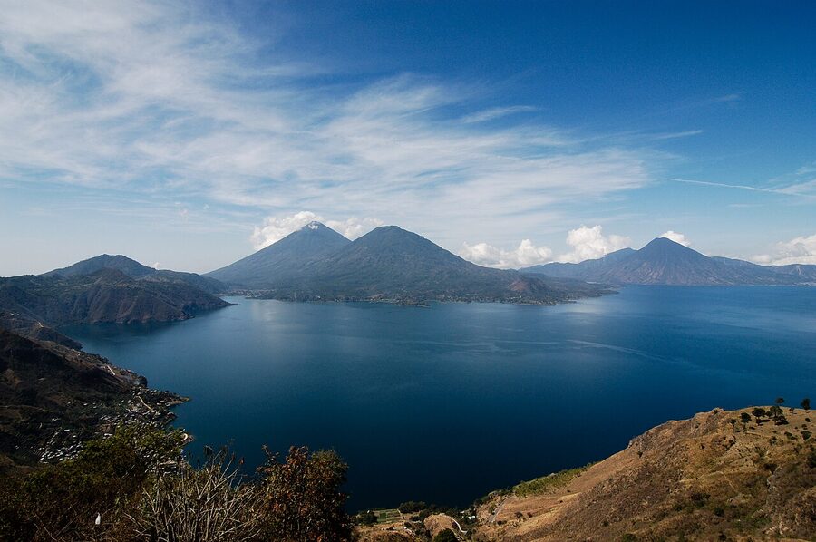Panoramic view of Lake Atitlan from a high overlook showing all three volcanoes