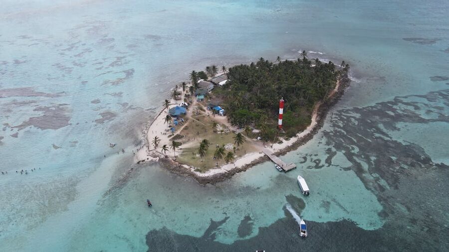 Aerial view of a Guna Yala island with a lighthouse and turquoise reefs