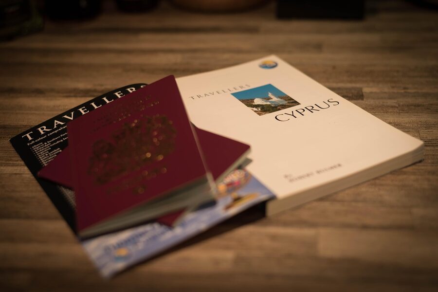 Open passport with handwritten stamps on a wooden surface