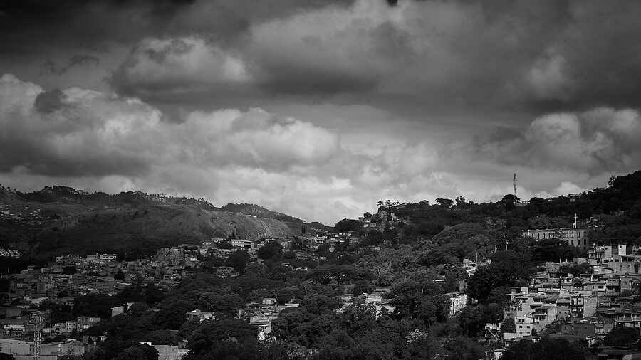 Tegucigalpa cityscape in dramatic black and white with surrounding hills and stormy sky