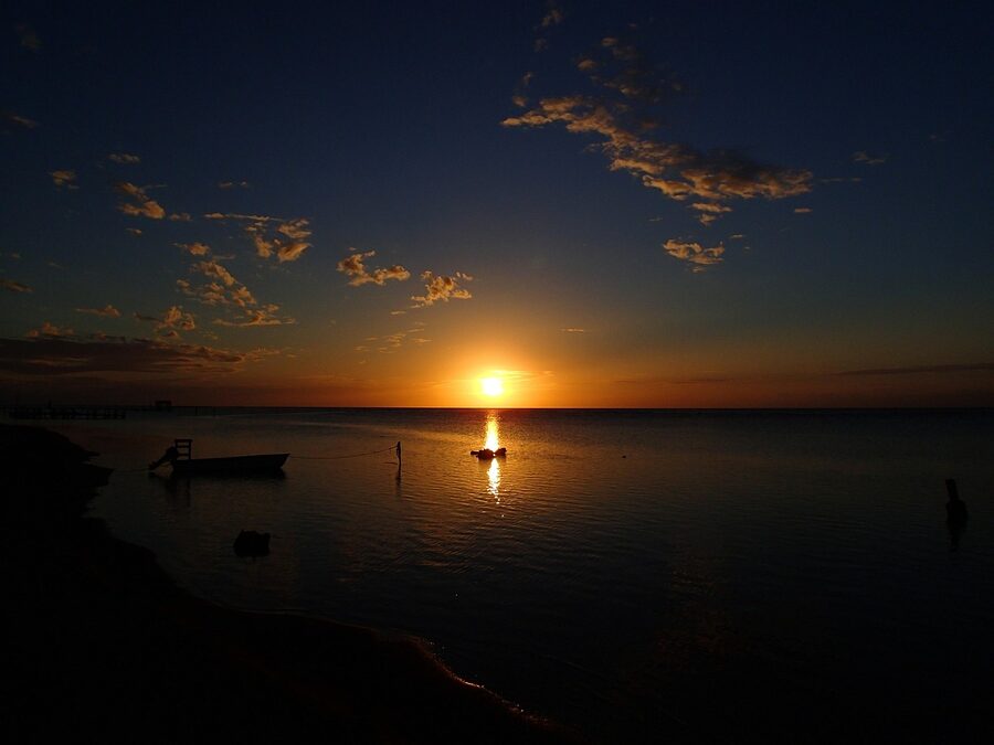 Sunset over the water at Roatán with boat