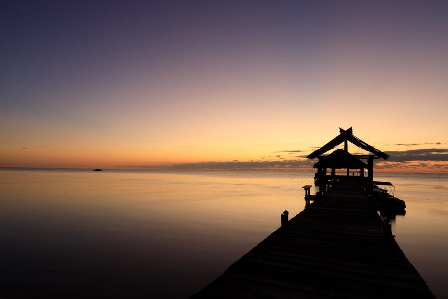 Wooden pier extending into the sea at sunset on San Pedro Belize