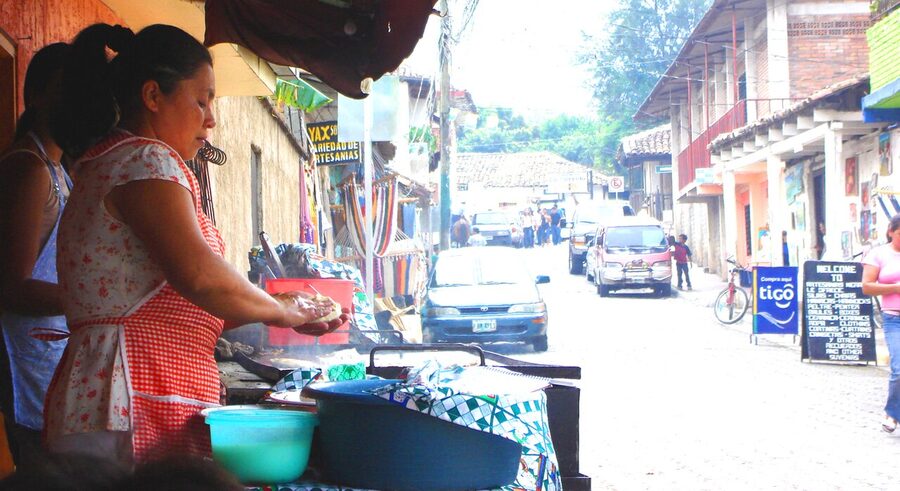 Honduran woman cooking pupusas at a street stall in Valle de Angeles