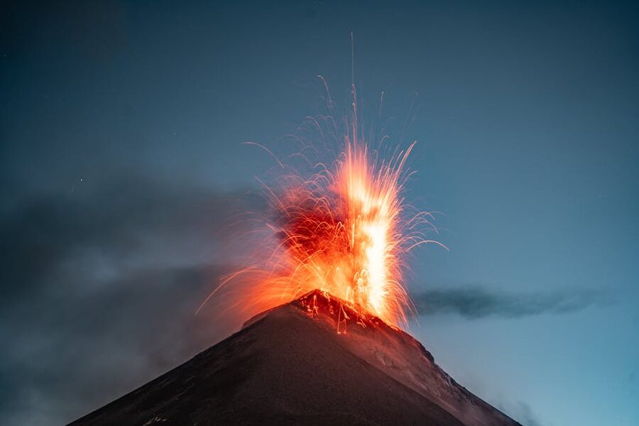 Volcan de Fuego erupting with sparks visible from Acatenango basecamp at dusk, Guatemala